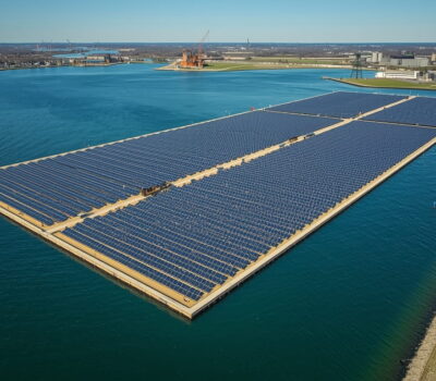 Aerial view of the United States’ largest floating solar farm on Lake Erie in northern Ohio, showing 200 acres of sun-tracking solar panels on the water surface generating clean energy for 15,000 homes while reducing harmful algae blooms